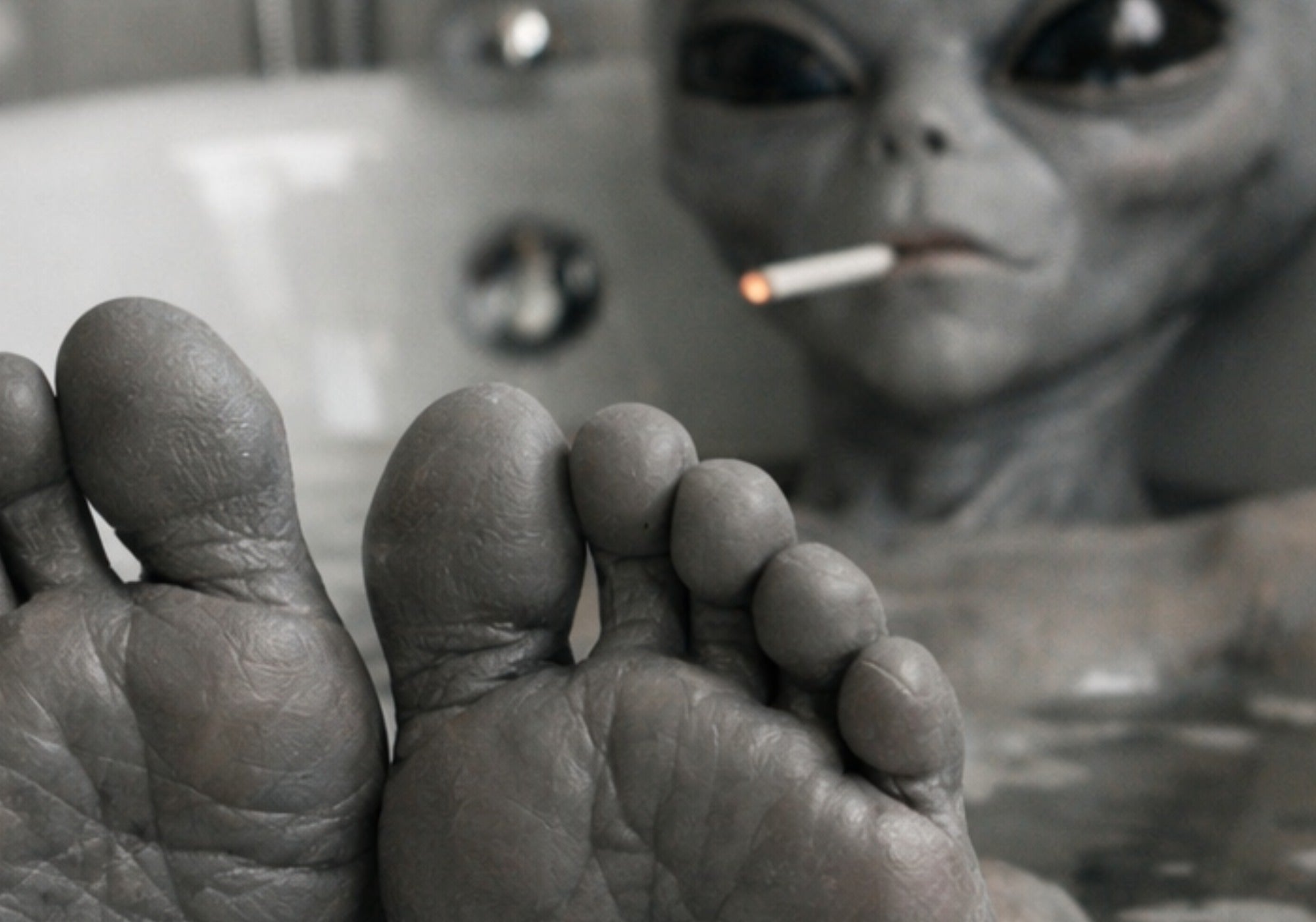Close up of alien in the tub with a cigarette